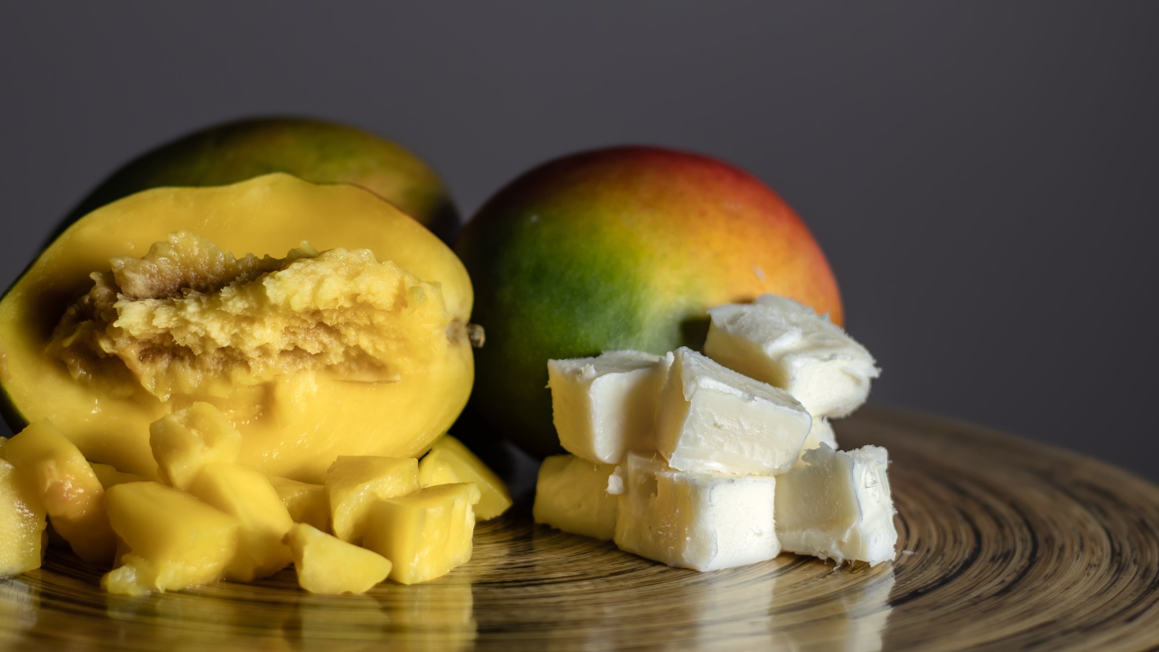 Fresh mangos beside ultra-rich mango butter, the nourishing base ingredient used in The Butter Bar’s natural skincare products.