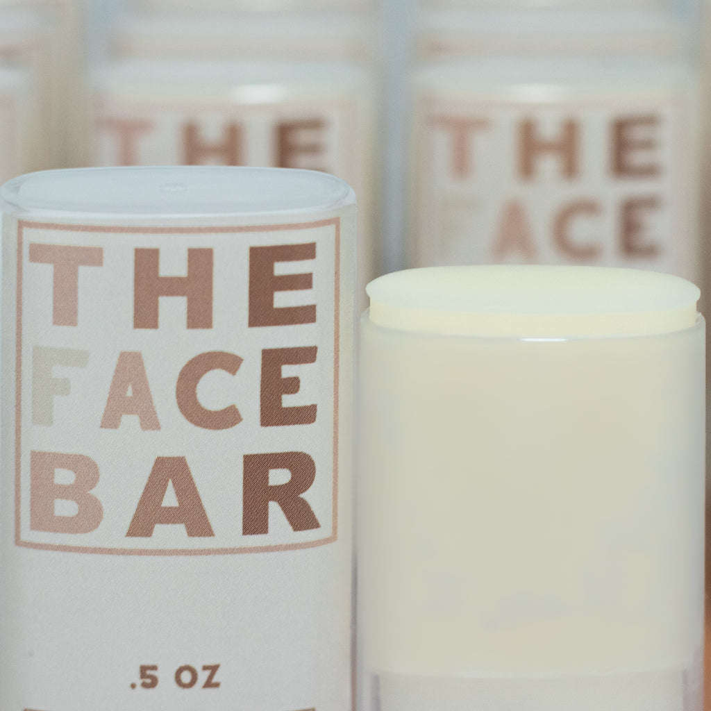 Small portable roll up container labeled 'The Face Bar' with a white lid.